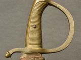 a close up of a sword with a wooden handle on a table