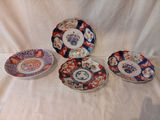 Plusieurs assiettes aux motifs variés sont disposées sur une nappe blanche