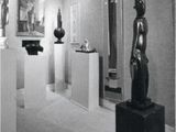 a black and white photo of a museum with sculptures