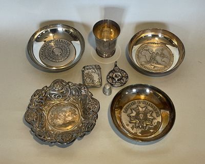 five silver dishes and two silver cups on a table