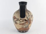 a vase with a painting on it sitting on a table