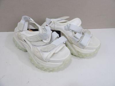des chaussures à semelles compensées blanches, avec des semelles blanches, posées sur une surface blanche