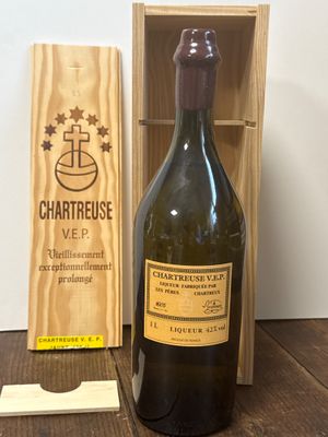 une bouteille de vin à côté d'une caisse en bois sur une table