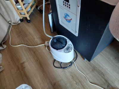 a black and white machine sitting on the floor next to a chair
