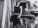 photo en noir et blanc d'une femme assise à l'arrière d'un camion