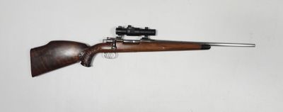 Gros plan sur un fusil équipé d'une lunette de visée, sur fond blanc