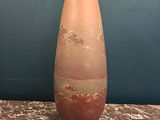 a large vase sitting on a table with a blue wall behind it