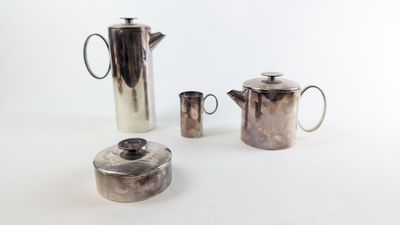 trois cafetières en argent et une théière posées sur une table