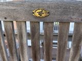 a wooden bench that has a metal handle on it