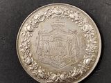 a close up of a silver coin with a crest on it