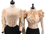 two mannequins with dresses on display on a white background
