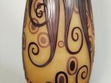 a vase with swirly designs on it sitting on a table