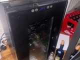 a wine cooler sitting on a wooden table next to a computer