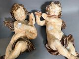 deux figurines représentant Cupidon en train de jouer de la musique, posées sur une table