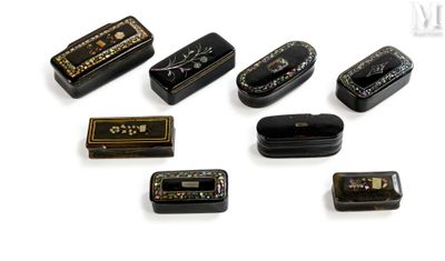 a lot of small black and gold tins on a white surface