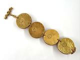 gold bracelet with four circles and a cross on a chain