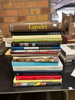 a stack of books sitting on a table next to a brick wall