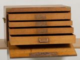 a wooden box that has five drawers on it