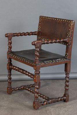 une vieille chaise en bois avec une assise en cuir et un cadre en bois