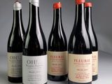 four bottles of wine are lined up on a table