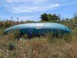 un grand bateau bleu au milieu d'un champ