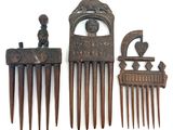 three pieces of antique hair combs are displayed on a white surface