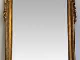an ornate gold framed mirror on a white wall