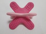 a close up of a pink pacifier sitting on top of a white table