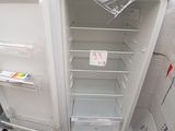 a white refrigerator with its door open in a warehouse