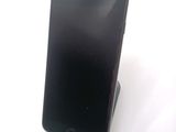 a black cell phone sitting on top of a stand