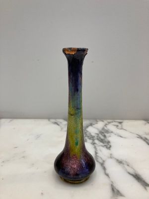 purple and green glass vase sitting on a marble counter top