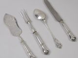 quatre cuillères en argent, un couteau et une fourchette posés sur une table