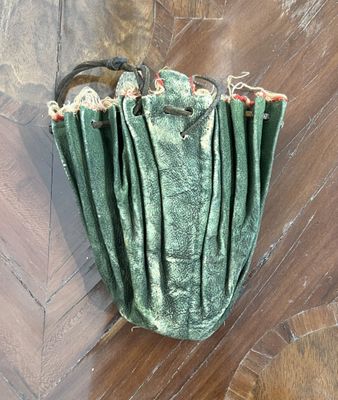 a green purse that is on the floor on the floor