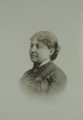 une vieille photo en noir et blanc d'une femme en robe