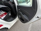 a white car with its door open and a box in the back