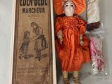 a doll that is sitting on a table next to a book
