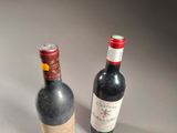 two bottles of wine sitting next to each other on a table