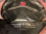 a red and black purse that is open on the floor
