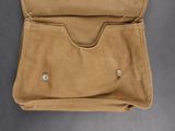 an old tan purse with a button on the inside of it