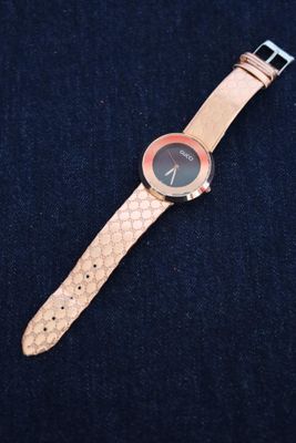 a close up of a watch on a blue surface with a black background