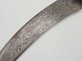 an old knife with a metal handle sitting on top of a white table
