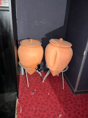 deux pots orange posés côte à côte sur des tabourets