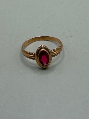 une image d'une bague en or avec une pierre rouge