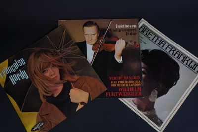 trois pochettes différentes de CD de musique sur un fond noir