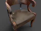 une vieille chaise avec une assise en cuir sur un fond sombre