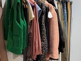 a rack of clothes hanging on a rail in a room