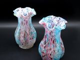 two vases that are sitting on a black surface