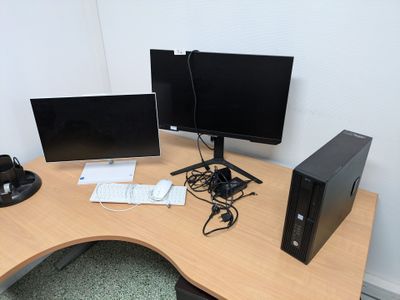 a desk with two monitors and a keyboard on it