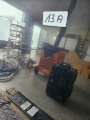 une valise posée par terre à côté d'une pile de bagages