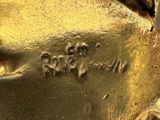 a close up of a gold statue with writing on it